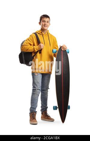 In voller Länge Porträt eines männlichen Teenagerstudenten in einem Gelber Hoodie steht und hält ein Longboard isoliert auf weiß Hintergrund Stockfoto