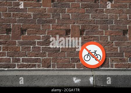 Fahrradparken verboten, ein rundes Metallschild an einer Backsteinmauer in der Altstadt von Rotterdam, Niederlande, Europa. Stockfoto