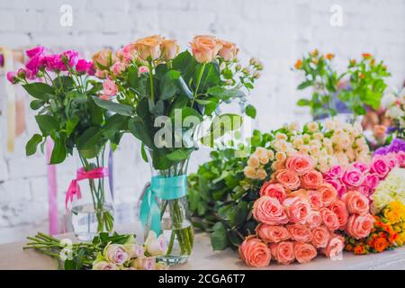 Bunte schöne Blumensträuße - Rosen auf dem Tisch im Studio, Blumenladen. Floristik, romantisch, Urlaub, Geburtstag, valentinstag, Hochzeit Stockfoto