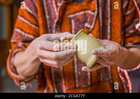 Professionelle männlichen potter Prüfung Steingut Becher in Töpferei, Studio. Handwerk, Kunst und Handarbeit Konzept Stockfoto