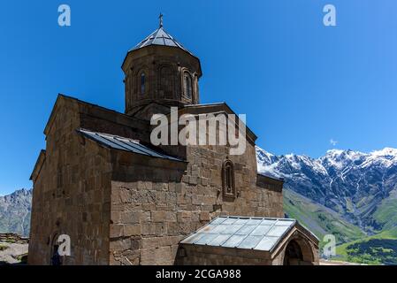 Trinity Kirche auf dem Berg vor dem Hintergrund von Felsen Im Dorf Gergeti an der georgischen Militärstraße Stockfoto