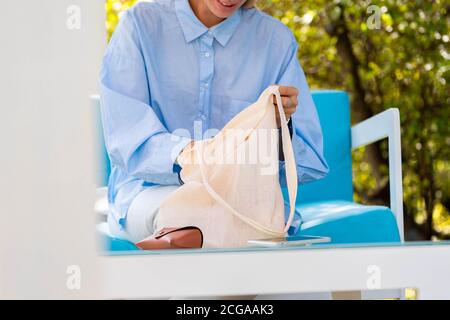Nahaufnahme der Frau Putting Handy in Baumwolle biologisch abbaubar Blank White Bag. Umweltfreundliche Produkte. Speicherplatz Kopieren. Leerer Raum Stockfoto