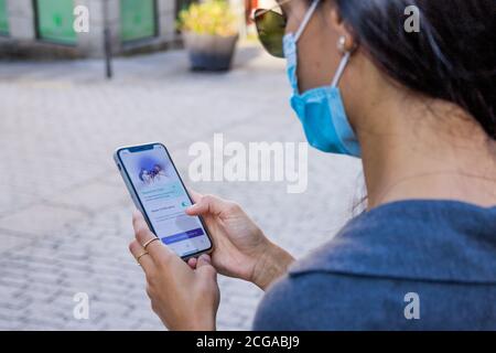 Mädchen mit der neuen öffentlichen Telefon-App zu beraten Infektionsgefahr durch Coronavirus in Spanien Stockfoto