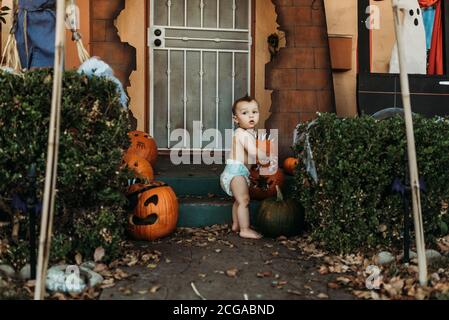 Baby Kleinkind Junge in Windel mit Halloween-Dekorationen im Herbst Stockfoto