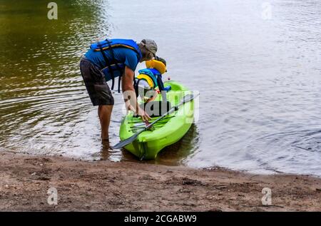 Großvater und Enkel sitzen in einem Kajak, um entlang zu segeln Der See entlang der Felsen im Kajak Stockfoto