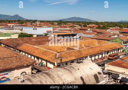 Leon, Nicaragua - 27. November 2008: Kathedrale von Mariä Himmelfahrt, Asuncion. Rote Dachstrukturen der Stadt, Metropolitan Supermarkt Platz vor. La Unio Stockfoto