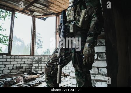 Waffen Nahaufnahme eines Militärs, der im Gebäude steht und auf das Kommando wartet. Stockfoto