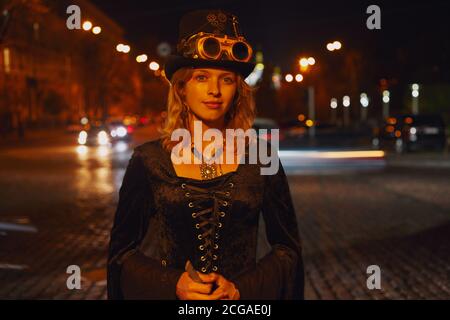 Frau im Steampunk halloween Kostüm bei Nacht auf der Straße. Stockfoto