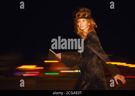 Frau im Steampunk halloween Kostüm bei Nacht auf der Straße. Stockfoto