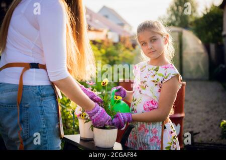 Gartenarbeit - Glückliche Mutter mit Tochter im Garten arbeiten Stockfoto