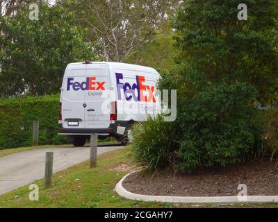 Ein FedEx-Van parkte, während er Pakete zu einer Wohnimmobilie, Queensland, Australien, lieferte Stockfoto