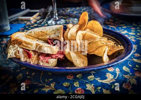 Ein rueben Sandwich auf einem Teller mit Kartoffelchips. Stockfoto