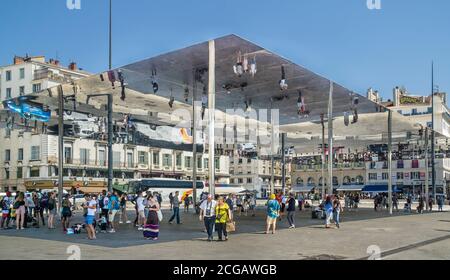 L'Ombrière de Norman Foster, ein poliertes Stahldach, das Besucher reflektiert, die unter dem Hotel herumlaufen, entworfen von Norman Foster im alten Hafen von Marseille, Bo Stockfoto