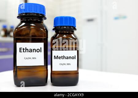 Selektiver Fokus von Ethanol und Methanol in Braunglasflaschenbehälter. Weißer Laborhintergrund mit Kopierbereich. Stockfoto