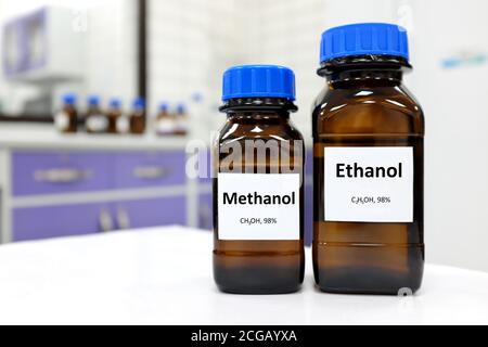 Selektiver Fokus von Ethanol und Methanol in Braunglasflaschenbehälter. Weißer Laborhintergrund mit Kopierbereich. Stockfoto