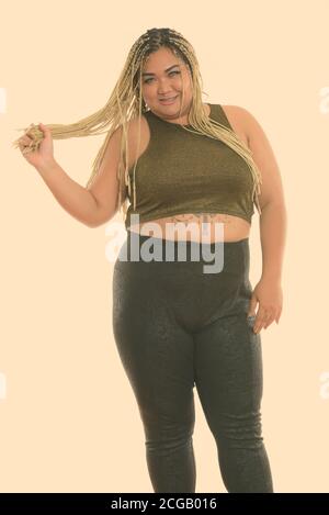 Studio shot der Jungen gerne Fett asiatische Frau lächelnd beim Stehen und spielen mit Ihrem Haar Stockfoto