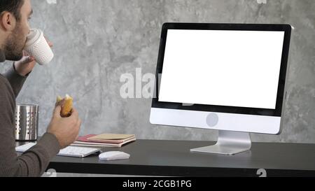 Besetzt Geschäftsmann in späten Mittagessen essen Sandwich im Büro arbeiten. Weißes Display. Stockfoto