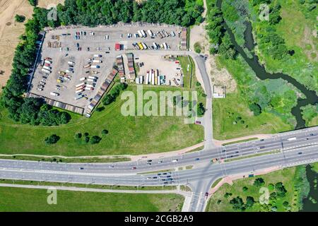 Luftdrohne Ansicht einer Vorstadtstraße mit Kreuzung und Parkplatz mit Lastwagen Stockfoto