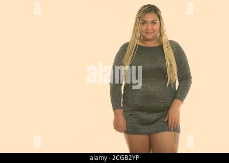 Studio shot der Jungen gerne Fett asiatische Frau lächelnd im Stehen Stockfoto
