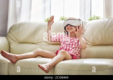 Nettes kleines Kind Mädchen spielen Spiel in Virtual Reality Brille. Stockfoto