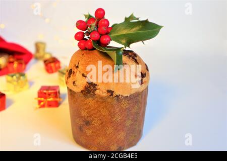 Weihnachtskarte. Italienische Weihnachtssüße (Panettone) mit Stechpalme auf weißem Hintergrund. Weihnachts- oder Neujahrsfest-Konzept. Kopieren Stockfoto