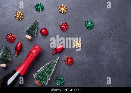 Weihnachtskomposition mit Champagner und roten, grünen, goldenen Geschenken und Schleifen auf dunklem Steingrund. Weihnachts- und Neujahrskonzept - Bild Stockfoto