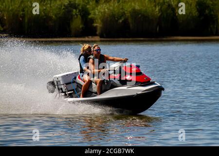 Eastern Neck Island, MD, USA 08/30/2020: Ein kaukasisches Paar mittleren Alters, das Lebenswesten trägt, ist auf einem Sea Doo GTX Personal Water Craft. Sie bewegen sich wirklich Stockfoto