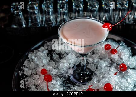 Der Barkeeper bereitet auf der Theke der dunklen Bar einen Cocktail mit Joghurt oder Milch zu. Stockfoto