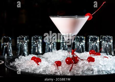 Der Barkeeper bereitet auf der Theke der dunklen Bar einen Cocktail mit Joghurt oder Milch zu. Stockfoto