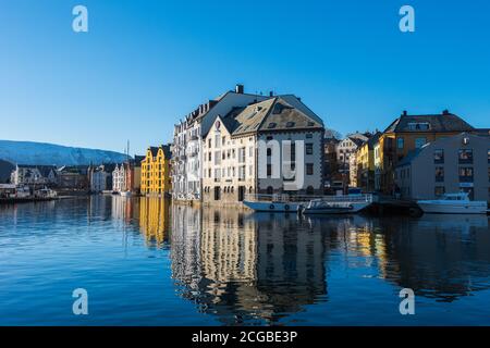 Schöne alte Steinhäuser mit Jugendstilfassaden direkt an Die Uferpromenade in Ålesund an einem klaren sonnigen Wintertag Stockfoto