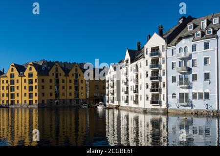 Schöne alte Steinhäuser mit Jugendstilfassaden direkt an Die Uferpromenade in Ålesund an einem klaren sonnigen Wintertag Stockfoto
