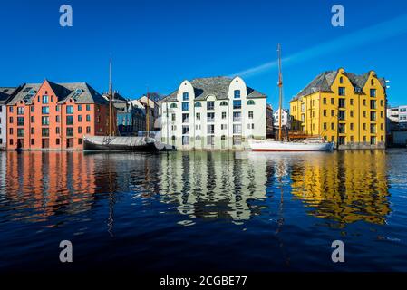 Schöne alte Steinhäuser mit Jugendstilfassaden direkt an Die Uferpromenade in Ålesund an einem klaren sonnigen Wintertag Stockfoto