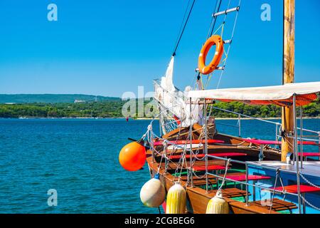 Hafenpromenade und alte Schiffe im Hafen in der Stadt Punat auf der Insel Krk, Adriaküste, Kroatien Stockfoto