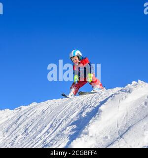 Kleine Skifahrer lernen auf einer gut präparierten Piste Ski zu fahren und haben viel Spaß. Stockfoto