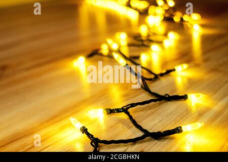 Girlande leuchtet mit warmem Licht auf dem Boden. Die Atmosphäre der Weihnachtsferien. Stockfoto