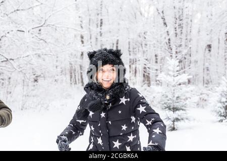 Spaß, Saison und Freizeitkonzept - Liebespaar spielt Winterholz auf Schnee Stockfoto