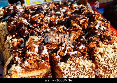 In Scheiben geschnittener Kuchen aus nächster Nähe. Schokoladenkuchen mit Erdnüssen auf einem Tablett Stockfoto