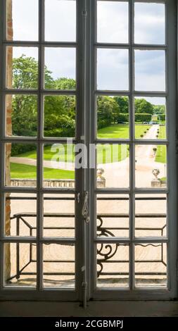 Blick auf den regulären Park durch ein Fenster mit Bars. Sommer Stockfoto