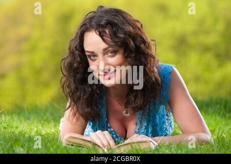 Dame mit offenem Buch auf frischem Gras Stockfoto