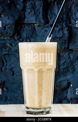Brown Smoothie oder Cocktail mit Kaffee und Joghurt in einem Großes Glas an einer dunklen Steinwand Stockfoto
