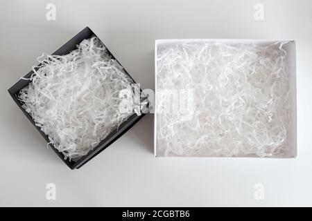 Geöffnete Geschenkschachteln mit dekorativem Stroh, Füllstoff, Späne. Papierbox für Ihre Produktplatzierung oder Montage. Geschenkverpackung. Draufsicht, flach liegend Stockfoto