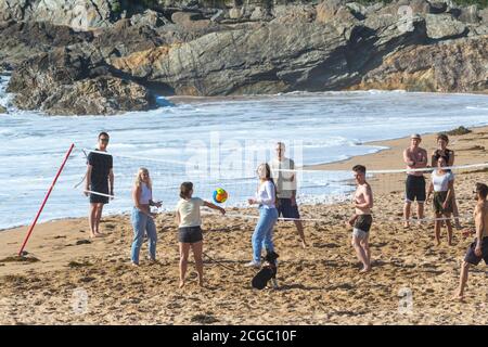 Eine Gruppe von Urlaubern spielt eine Partie Volleyball am Fistral Beach in Newquay in Cornwall. Stockfoto