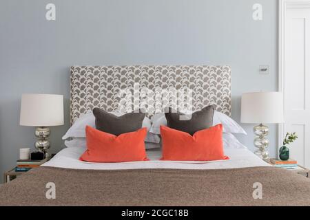 Kissen auf einem Bett in einer renovierten Wohnung in Hove, East Sussex, Großbritannien. Stockfoto