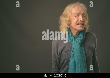 Älterer Mann mit Schnurrbart gegen grauer Hintergrund Stockfoto