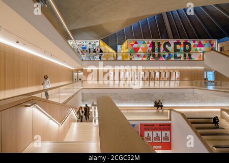 The Design Museum, London, Innenansicht, Menschen auf Treppen und Gehwegen, zentrales Atrium und angewinkelte Dachstreben. Stockfoto