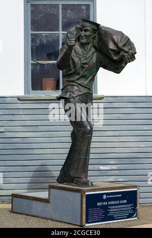 Fremantle, Western Australia - August 2020: Das Australian Sailor Monument. Smailing Seemann in Uniform hält Seesack und zeigt OK Zeichen. Die Th Stockfoto