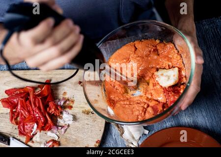 Nahaufnahme eines Mannes, der typisch spanische Salmorejo cordobes oder Porra antequerana, eine kalte Tomatensuppe, mit Tomaten, Brot, Olivenöl und Knoblauch hergestellt, zubereitet Stockfoto