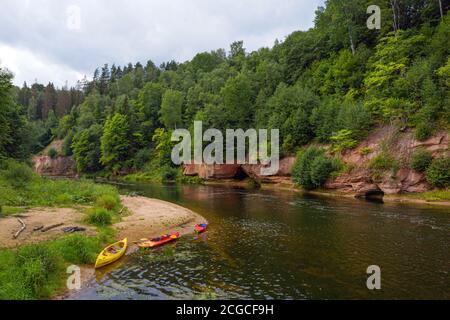 Landschaft mit Sandsteinfelsen, Kanus und Kajaks am Gauja-Ufer, schnell fließendem und klarem Flusswasser, Kuku-Klippen, Gauja-Nationalpark, Latv Stockfoto