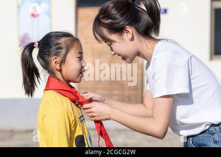 (200910) -- LINGCHUAN, 10. September 2020 (Xinhua) -- Chen Yanzi bindet den roten Schal für den Schüler Fu Zhenzhen im dritten Jahr an der Mawuzhai Internat Grundschule in der Gemeinde Gujiao im Landkreis Lingchuan, Stadt Jincheng, Provinz Shanxi, 9. September 2020. In den Tiefen des Taihang-Gebirges, mehr als 1,300 Meter über dem Meeresspiegel gelegen, ist die Mawuzhai Internat-Grundschule mit ihren ganzen sechs Schülern die einzige Schule im Umkreis von Dutzenden von Kilometern. Chen Yanzi kam im Alter von 25 Jahren im September 2019 hierher und wurde Lehrer. Chen Yanzi kam aus der Innenstadt der Stadt Jincheng, und es t Stockfoto