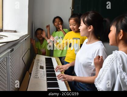 (200910) -- LINGCHUAN, 10. September 2020 (Xinhua) -- Chen Yanzi singt für Schüler der Mawuzhai Internat-Grundschule in der Gemeinde Gujiao des Landkreises Lingchuan, Stadt Jincheng, nordchinesische Provinz Shanxi, 9. September 2020. In den Tiefen des Taihang-Gebirges, mehr als 1,300 Meter über dem Meeresspiegel gelegen, ist die Mawuzhai Internat-Grundschule mit ihren ganzen sechs Schülern die einzige Schule im Umkreis von Dutzenden von Kilometern. Chen Yanzi kam im Alter von 25 Jahren im September 2019 hierher und wurde Lehrer. Chen Yanzi kam aus der Innenstadt der Stadt Jincheng und es dauerte mehr als drei Stunden mit dem Auto Stockfoto